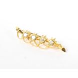 An early 20th century Continental unmarked yellow metal and diamond bar brooch with four flower