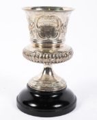 A William IV silver trophy of urn form, with repousse decorated floral sprays, over gadroons,