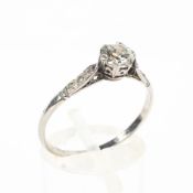 An early 20th century platinum and diamond dress ring with central 4mm diamond in a six-claw