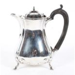An early 20th century silver lidded hot water jug of waisted form,