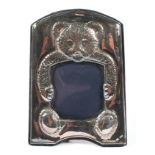 A vintage silver mounted child's photograph frame, the embossed mount depicting a teddy bear,
