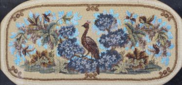A Victorian beadwork and woolwork panel, woven with a bird amongst flowers and foliage, framed,