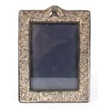 A vintage silver mounted picture frame, the mount decorated with embossed foliate motifs,