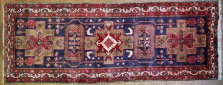 A Kordi blue-ground rug, woven in red and cream