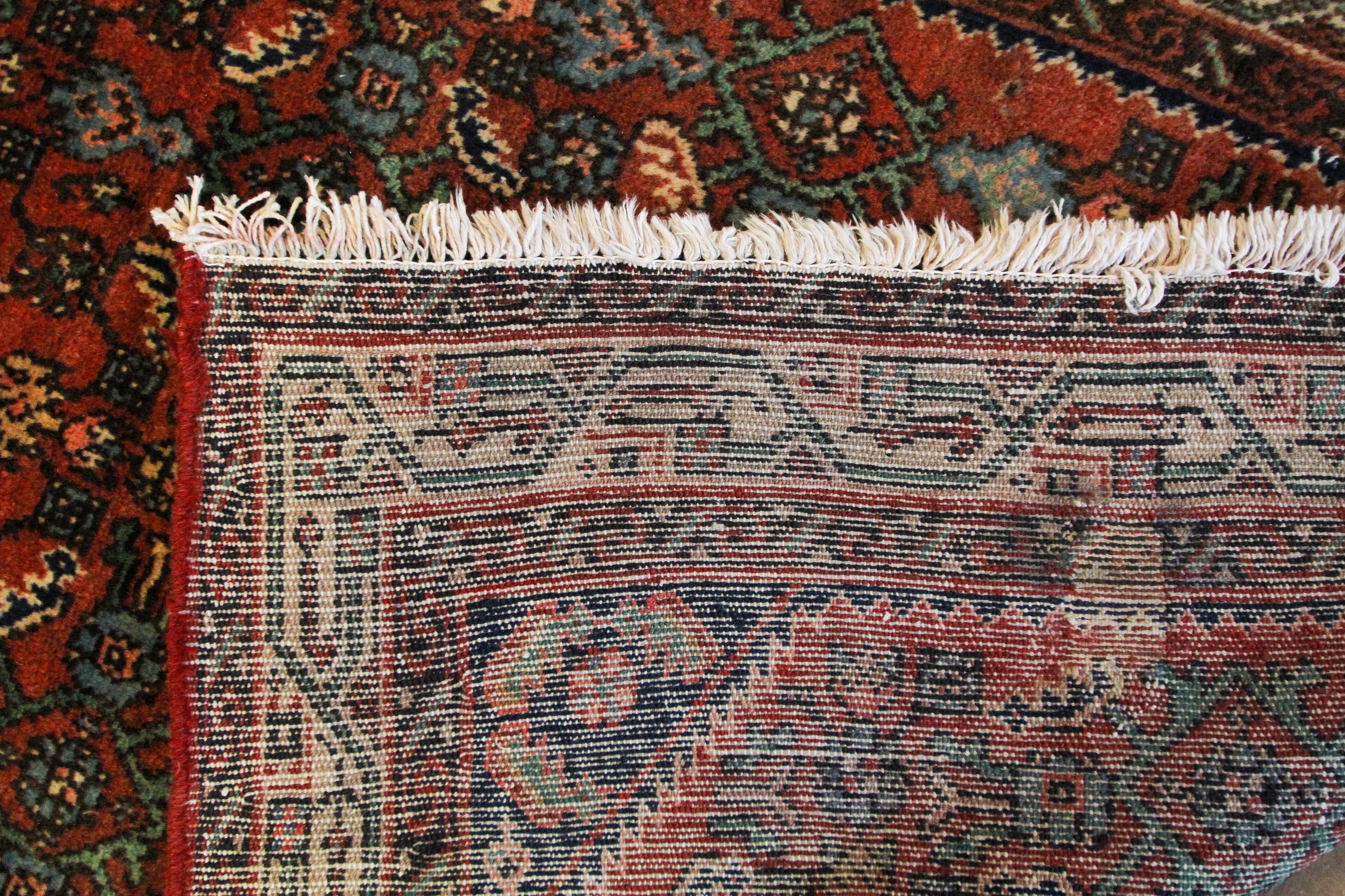 A Hamedan dark red ground rug, woven with a repeated geometric design in cream, blue and red. - Image 3 of 3