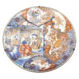 A large Japanese 19th century Imari charger decorated with three scholars in a bamboo grove,