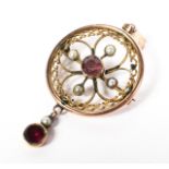 A 9ct gold circular pendant brooch set with garnets and seed pearls