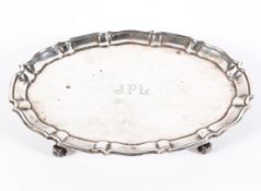 A George V silver footed salver of oval form with pie crust border,