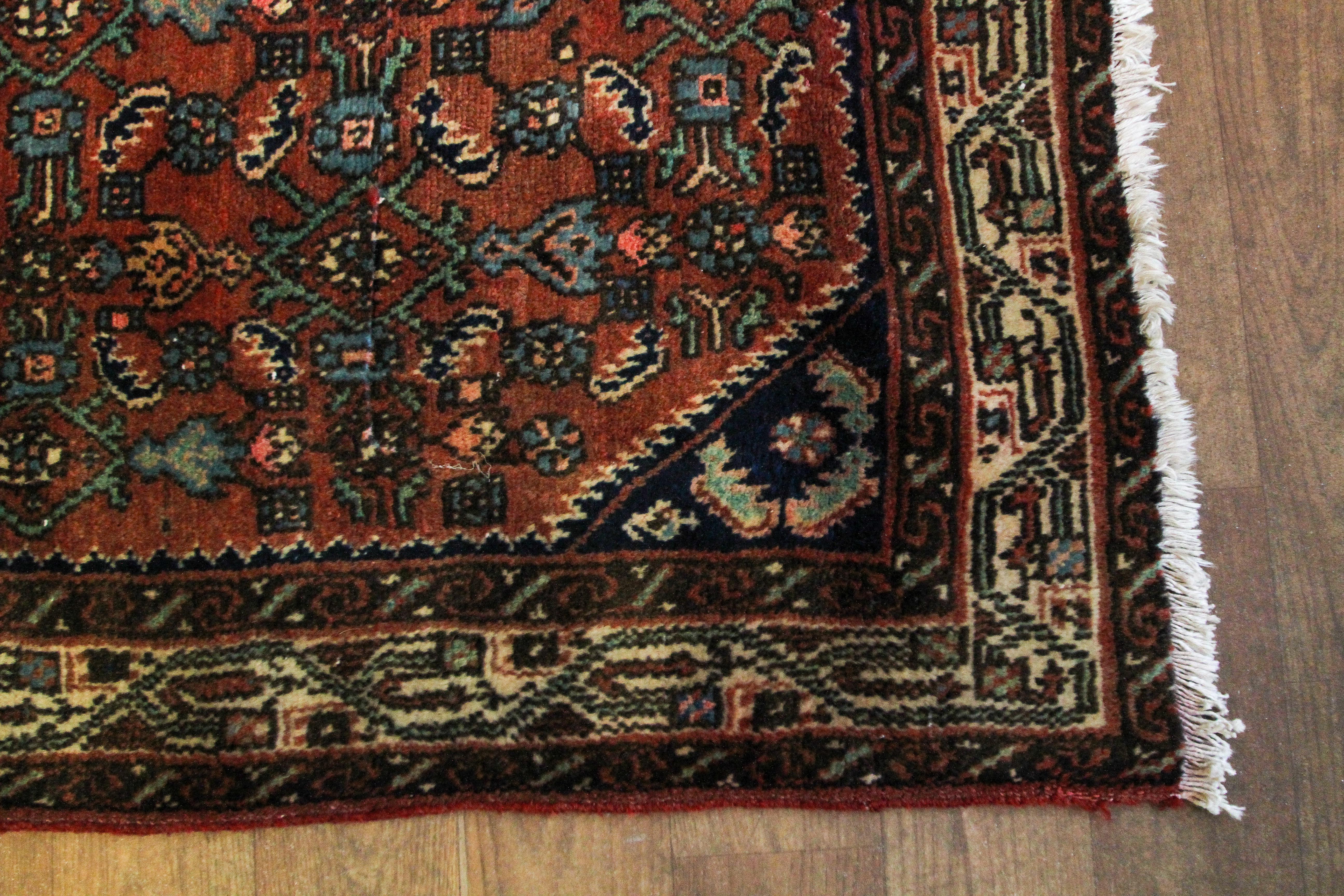 A Hamedan dark red ground rug, woven with a repeated geometric design in cream, blue and red. - Image 2 of 3