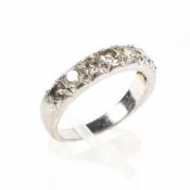 An early 20th century white metal half eternity diamond ring set with eight clawset brilliant cut