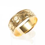 A late 19th century/early 20th century 18ct gold wedding band with highly engraved foliate