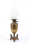 A late 19th century brass oil lamp, the urn shaped body with embossed foliate decoration,