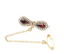 A 19th century 9ct gold garnet and seed pearl bow brooch set with two pear cut foil backed garnets