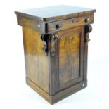 A mahogany side cabinet, the carved door opening to reveal two interior shelves,