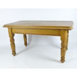 An early 20th century pine dining table of rectangular form, raised upon turned supports,