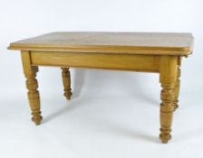 An early 20th century pine dining table of rectangular form, raised upon turned supports,