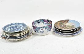 A selection of ceramic plates and a bowl, some with countryside scenes and blue and white designs