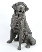 A resin gilt effect sculpture of a dog, in a seated position,