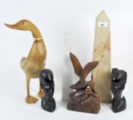 A collection of carved wooden sculptures and two stone obelisks,