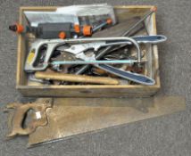 A collection of vintage tools, including saws, a pair of shears, an axe, wrenches and more,