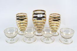 A set of Art Deco style glasses and two vases, all on circular bases with gilt decoration,