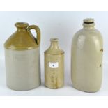 Three stoneware flagons, the largest with a loop handle and a two-tone glaze, height 27cm,