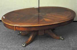 A reproduction mahogany veneer coffee table of oval form,