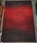 A red ground rug with a graduated black wave pattern,