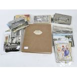 An early stamp album containing various GB world stamps, and a selection of postcards