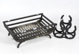 A cast metal fire grate and wine rack, the black fire grate with curved feet, width 57cm,
