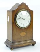 An early 20th century mahogany cased mantle clock with inlaid marquetry detailing,