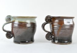 Two salt glaze mugs with scrolled handle and studio pottery mark