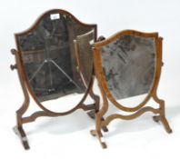 Two 20th century toilet mirrors, both of shield form and raised on curved supports,