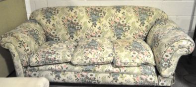 An early 20th century mahogany three seater sofa, with scroll arms and turned supports,