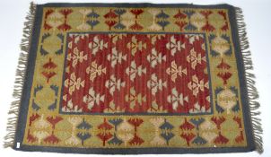 A Kilim style rug, featuring red, blue, yellow and green ornaments