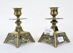 A pair of brass candlesticks, with pierced scrolling decoration,