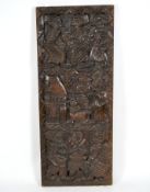 A rectangular deeply carved wooden plaque, depicting tribal figures,