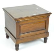 An early 20th century mahogany commode with folding armrests and hinged lid,