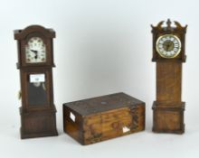 Two miniature wooden models of clocks and a hinged wooden box,