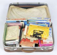 A vintage suitcase containing a large assortment of ordinance survey and similar folding maps