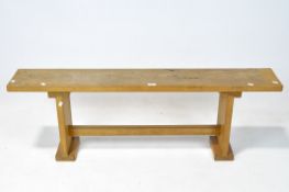 A mid 20th century pine bench, with cross stretcher and shaped upright supports,