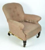 A 20th century button back armchair, upholstered in pink fabric and raised on turned wooden legs,