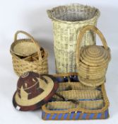 A collection of wicker items, comprising a washing basket, a compartmented tray, hats and baskets