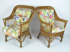 Two vintage wicker armchairs, both with floral upholstered cushions,