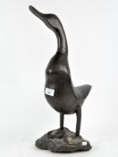 A wooden figure of a standing duck on a stand,