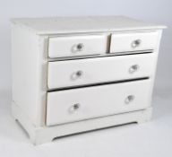 A white painted pine chest of drawers with two short drawers over two long,