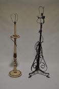 Two standard lamps, the first on scroll wrought iron supports, the other on a neo-classical style,