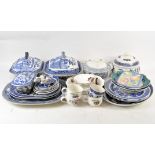 A large selection of blue and white ceramics, including multiple pieces in the 'Willow' pattern,