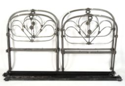Two contemporary single wrought iron beds with flower motifs,