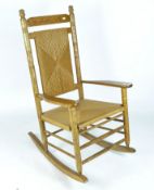 A 'The Cracker Barrel' rocking chair, a vintage oak rocking chair with wicker seat and back,